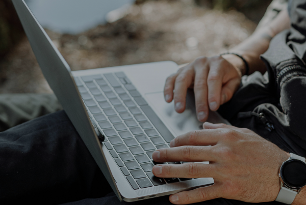 Mãos digitando em um notebook, representando a personalização e adaptação do PostgreSQL às necessidades do usuário.